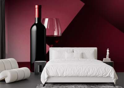 Bottle and glass of red wine on a red background. Wall mural