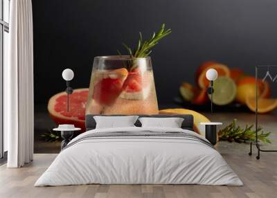 Cocktail gin tonic with ice, rosemary, and grapefruit on a stone table. Wall mural