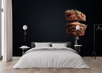 Medium rare beef steak with rosemary on a black background. Wall mural