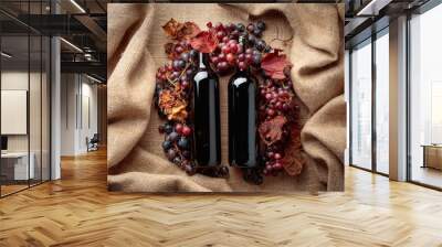 Red wine bottles and  grapes with dried up vine leaves. Wall mural