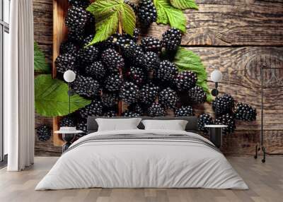 Ripe juicy blackberries with leaves on a wooden table. Wall mural