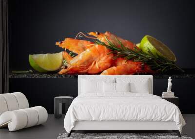 Shrimps with rosemary and lime on a black background. Wall mural