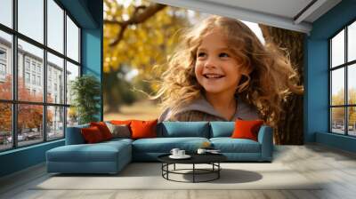 Portrait of a beautiful smiling little girl in the autumn park. Wall mural