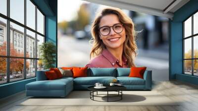 Portrait of a beautiful young woman with eyeglasses smiling at the camera Wall mural