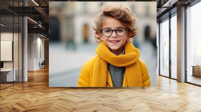 Portrait of a cute little boy wearing glasses and a yellow coat Wall mural