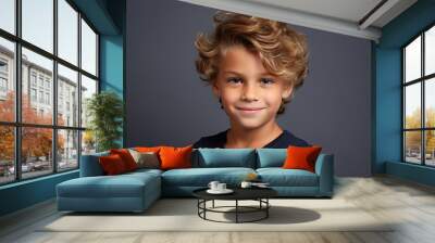 Portrait of a cute little boy with blond curly hair, over grey background. Wall mural