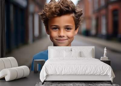 Portrait of a cute young boy with curly hair on the street Wall mural