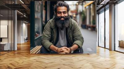 Portrait of a handsome bearded Indian man sitting on a bench in the street. Wall mural