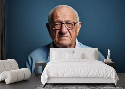 Portrait of an old man with glasses on a blue background. Wall mural