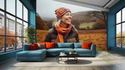 Portrait of happy senior woman in autumnal landscape looking at camera Wall mural