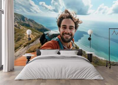 Young hiker man taking a selfie portrait on the top of mountain. Happy young athletic man on adventure Wall mural