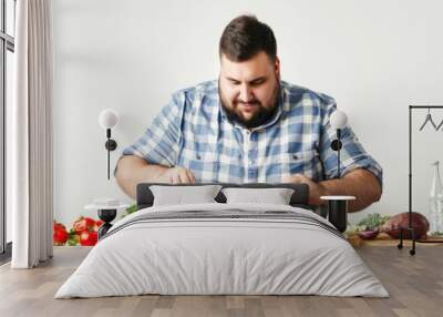 young overweight man preparing a delicious and healthy salad in the kitchen for her diet Isolated on white background Wall mural