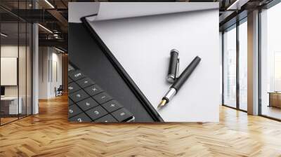 Clipboard with blank sheet and calculator on the black desk. Wall mural