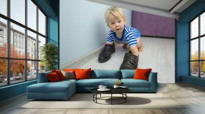 little boy playing with adult shoes Wall mural