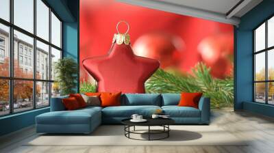 Christmas star red beautiful with tree branches on blurred red background Wall mural