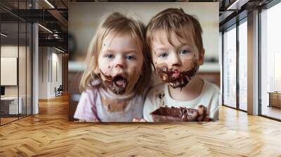 Funny siblings with messy face licking chocolate Wall mural