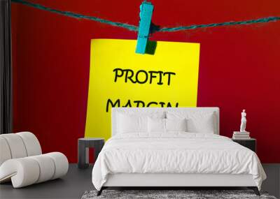 Business and financial concept. PROFIT MARGIN words. text written on a yellow sticker on a rope in front of a red background Wall mural