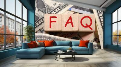 Concept word 'FAQ' on wooden cubes on a beautiful background from dollar bills. Business concept Wall mural