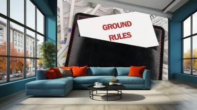 Conceptual ground rules symbol. Copy space. GROUND RULES words written on business cards in a business card holder against the background of American dollar bills Wall mural