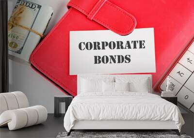 Finance and economics concept. CORPORATE BONDS written on a business card on a business notebook near money and a calculator on a white background Wall mural