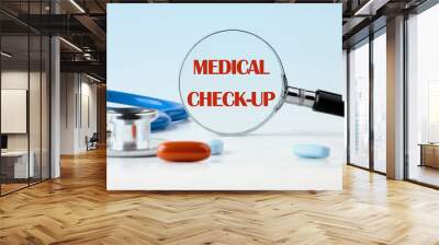 MEDICAL CHECK-UP words written view through a magnifying glass on a blue background Wall mural