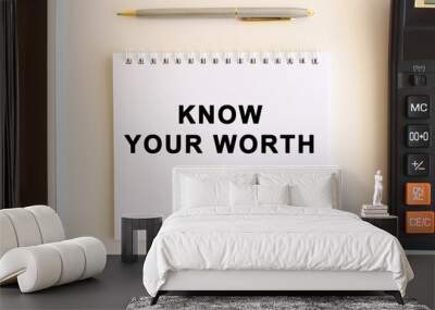 Notepad with text KNOW YOUR WORTH on a white background, near calculator, tablet and pen. Business concept. Wall mural