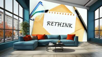 Rethink Business Concept text an inscription on a piece of paper peeking out of an envelope next to glasses and a pencil Wall mural