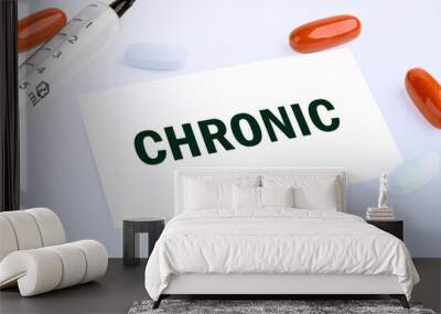 the word Chronic is written on a white business card lying on a light background Wall mural