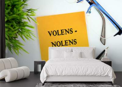 Willy - nilly latin expression volens-nolens (willing or unwilling) written on an orange sticker on a white background Wall mural