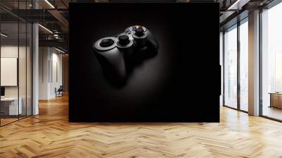 Wireless video game controller (gamepad) on a black background Wall mural