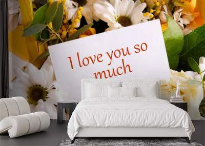 Words I love you so much written on a business card placed in a gift bouquet of flowers. Wall mural