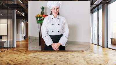 Portrait of a woman nutritionist in uniform with fresh vegetables on the table, A female nutritionist with a table of vegetables, Portrait of a female chef surrounded by fresh vegetables Wall mural