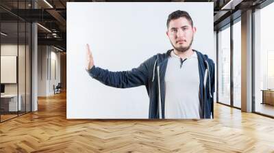 Young man making rejection gesture with palm of hand isolated. Displeased person rejecting gesturing stop isolated Wall mural