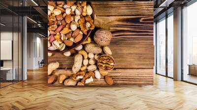 Various nuts (almond, cashew, hazelnut, pistachio, walnut) in ceramic plate on a wooden table. Vegetarian meal. Healthy eating concept. Top view Wall mural