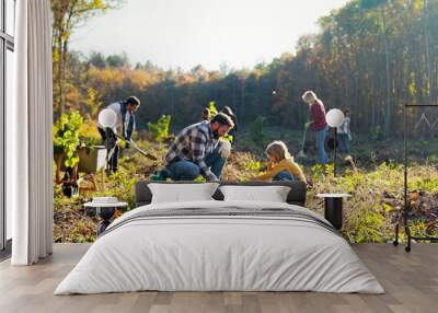 Happy father and child working together and planting seedling of tree in garden or forest on sunny autumn day. Outdoor. Caucasian dad and daughter cooperating for anti deforestation. Wall mural