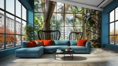 A vertical shot of two chairs and a window with plants in pots Wall mural