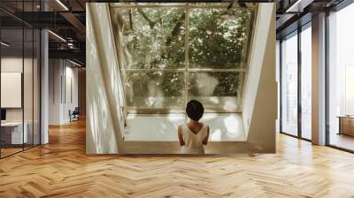 Back view of a young woman in a white dress looking out the window Wall mural