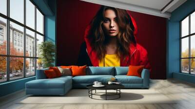 Beautiful young woman in a red jacket on a dark red background. Wall mural