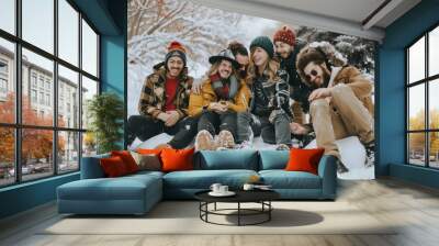 Group of friends having fun on the snow in the winter park. Wall mural