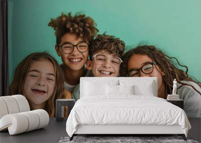 Group of happy children smiling and looking at camera on a green background Wall mural