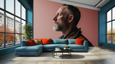 Portrait of a bearded man in a brown jacket on a pink background Wall mural