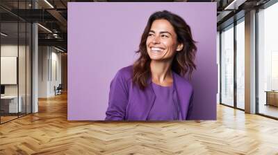 Portrait of a beautiful young woman smiling on a purple background. Wall mural