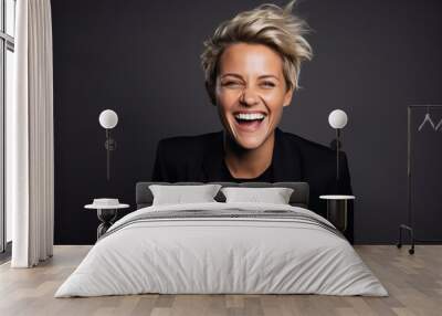 Portrait of a happy young business woman with short blonde hair over dark background Wall mural