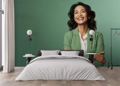 Portrait of a smiling businesswoman with crossed arms against green background Wall mural