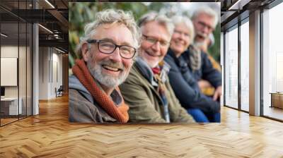 Portrait of happy senior friends sitting on bench in park and smiling Wall mural