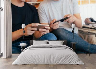 young men playing video games on smartphones. Wall mural