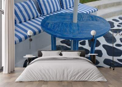 blue wooden table and chairs in tropical garden. blue white striped pillow backrest. Wall mural