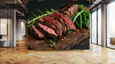 Spiced raw beef steaks on a wooden chopping board background. Sliced beef roast on a wooden board with green beans and rosemary against a wooden background. Steak dish. Copy space area for text Wall mural