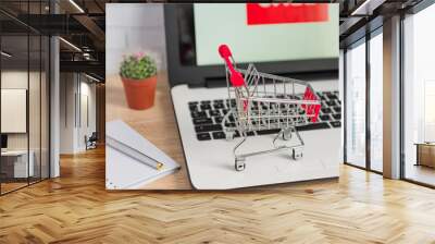 Small red shopping cart or trolley on laptop keyboard, Technology business online shopping concept Wall mural