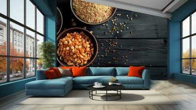 Bowls of cereals grains seeds and more on a black wooden background with copy space image Wall mural